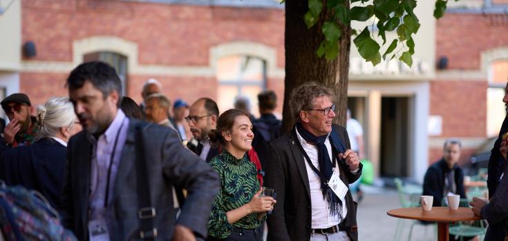 Two people standing in a courtyard smiling